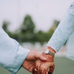 person wearing white long sleeve shirt and brown leather bracelet