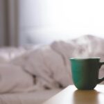 green ceramic mug on wooden desk