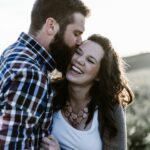 man kissing woman in grass area